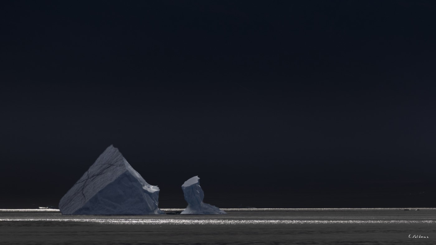 A pyramid-shaped iceberg in the dark